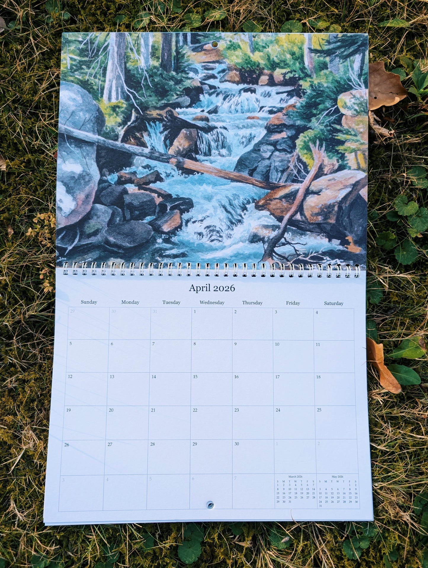 Calendar with a nature-themed design showing a stream in the woods