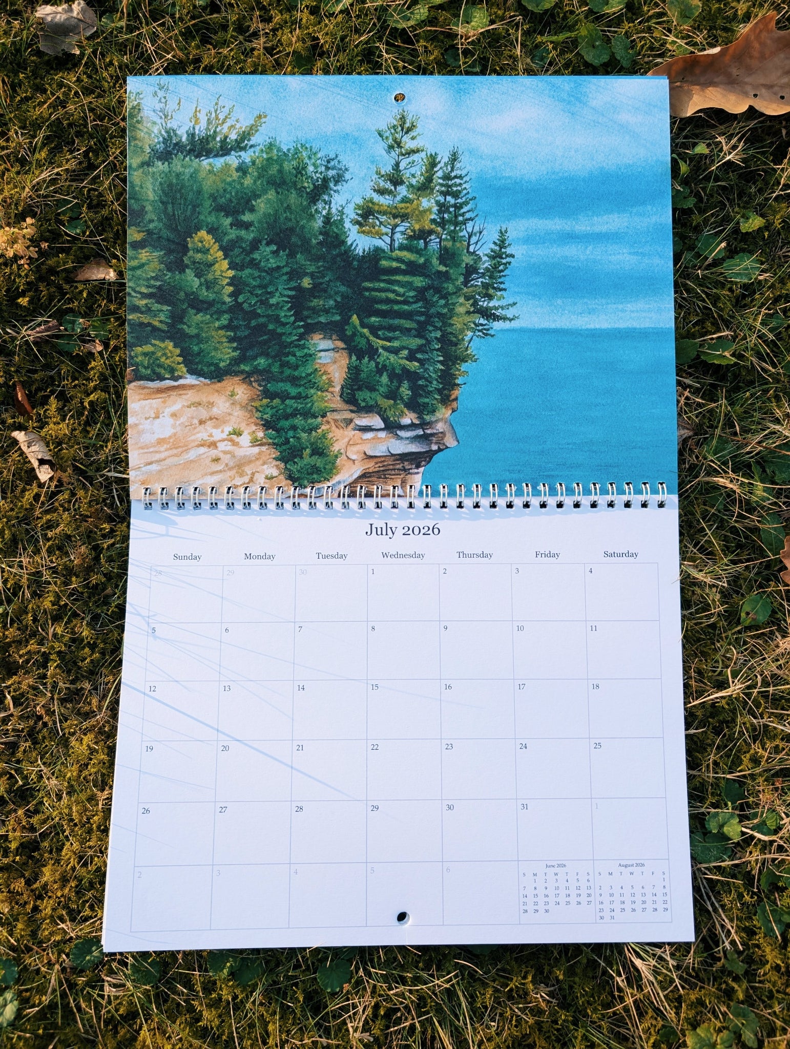 Calendar with a scenic design of trees on a rocky cliff over water