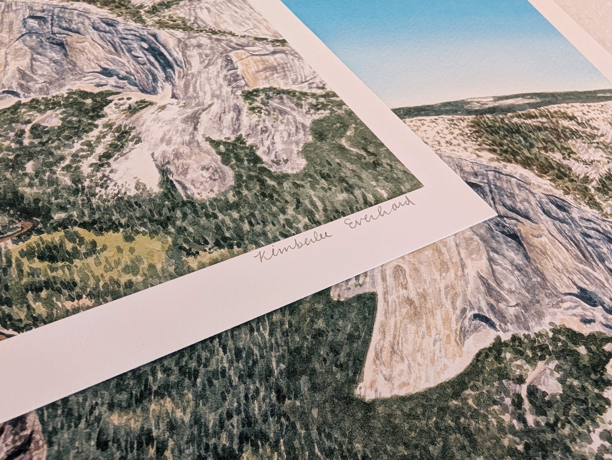 Scenic landscape print of a mountainous area with greenery and clear sky.