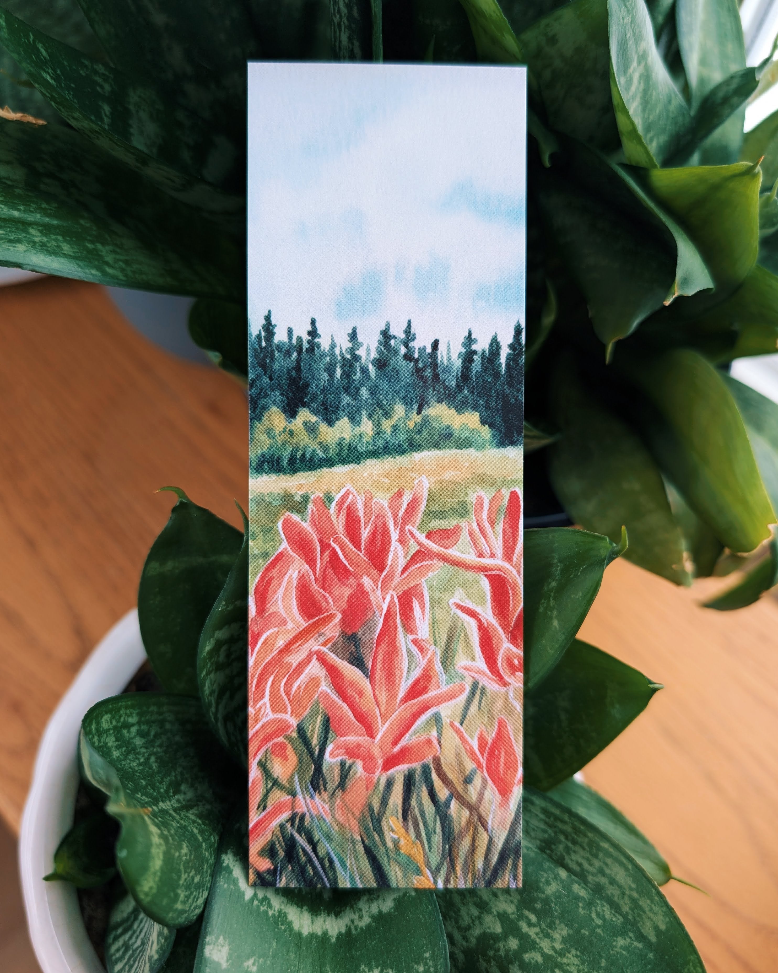 Artistic bookmark with pink floral design on a green plant background