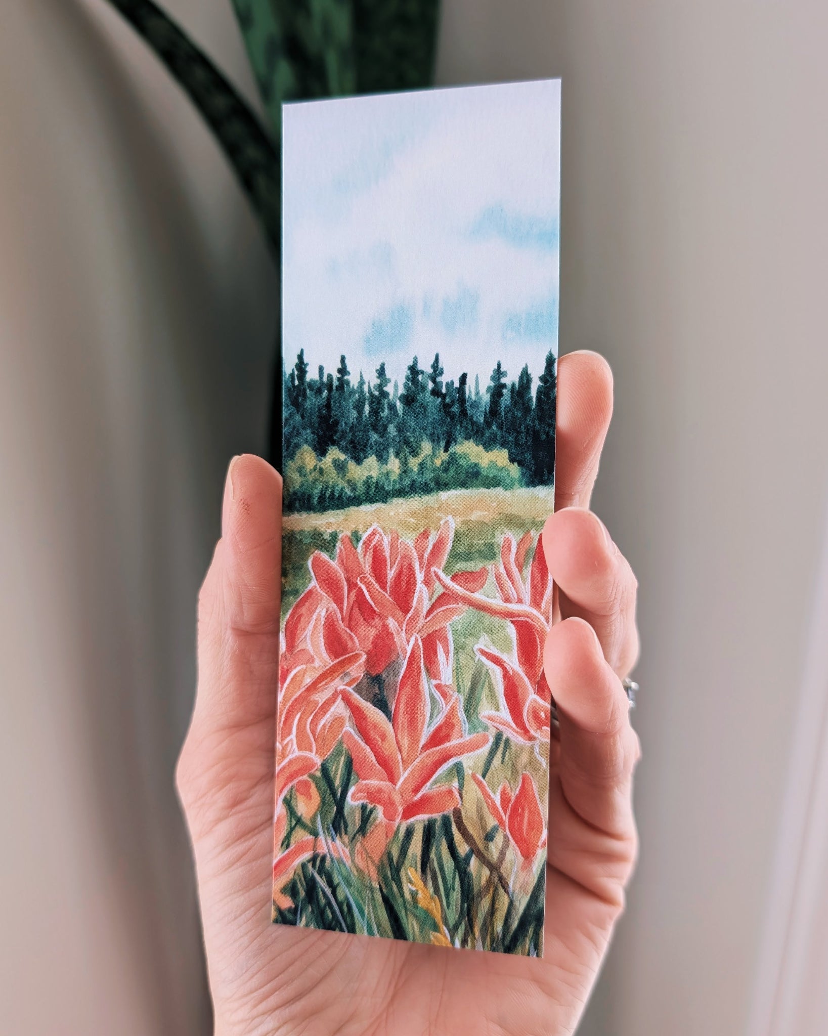 Hand holding a bookmark with floral design