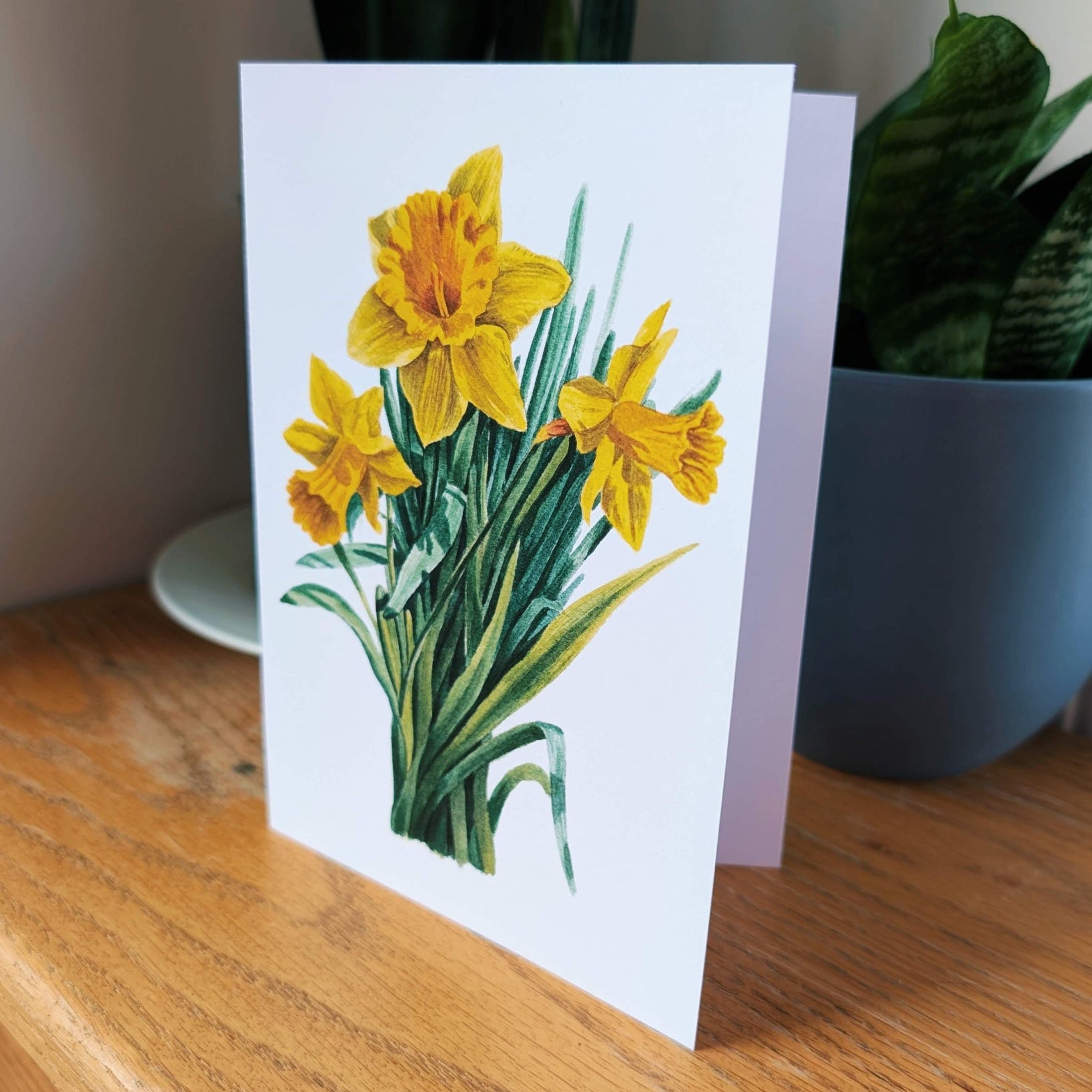 Greeting card with yellow flowers on a wooden surface