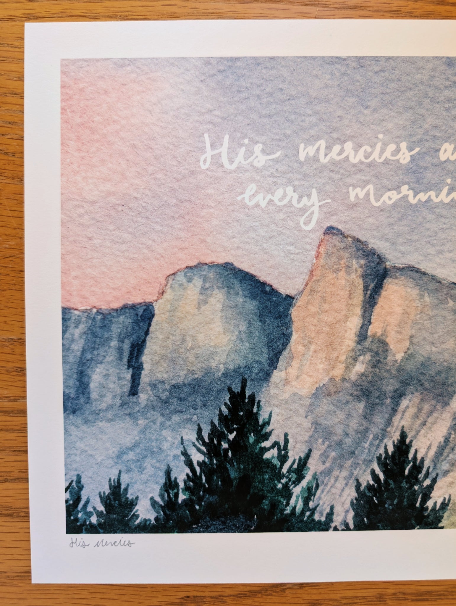 Mountain landscape with trees and 'His mercies are every morning' text on a watercolor background.