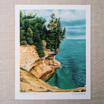 Pictured rocks national lakeshore watercolor painting with pine trees and bright blue water